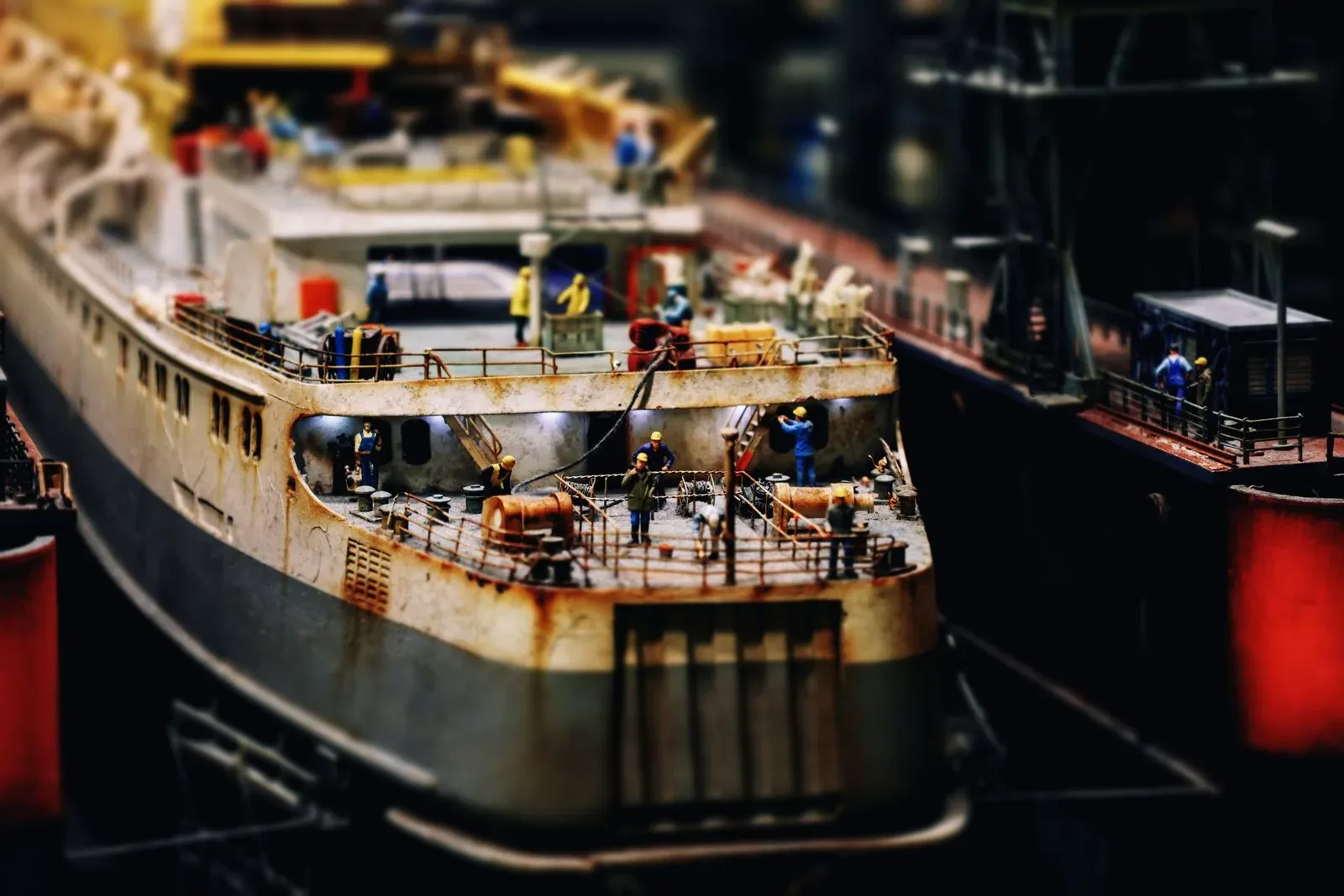 Detailed model ship with miniature sailors in a harbour diorama